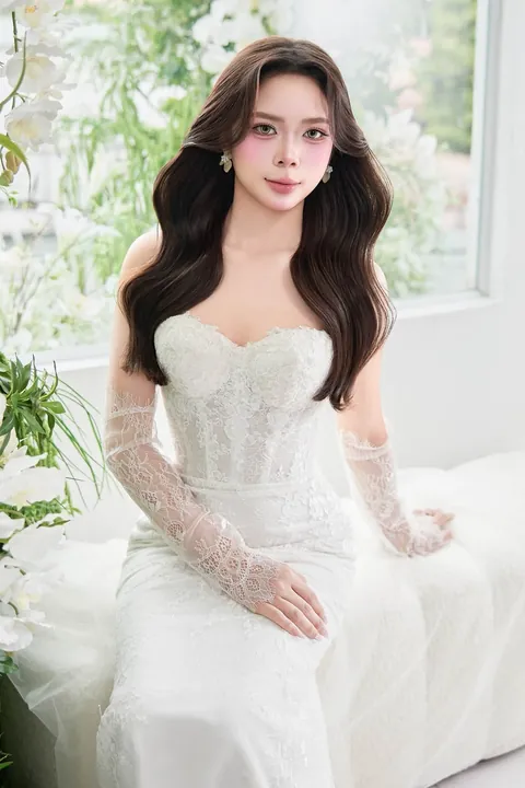 Cô dâu phong cách Hàn Quốc đặt tay lên ngực, mặc váy ren cúp ngực